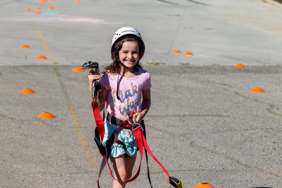 smiling girl in a zip line harness.