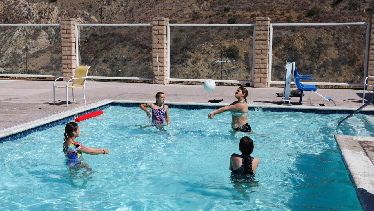kids playing volleyball in a pool.