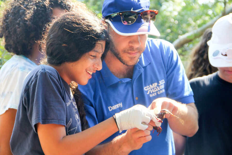 girl looking at a crustacean with a staff member.