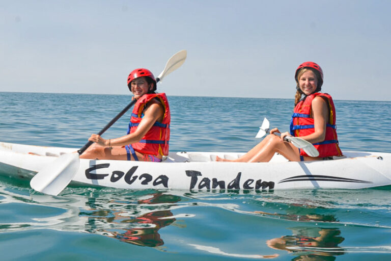 two girls on a kayak at sea.