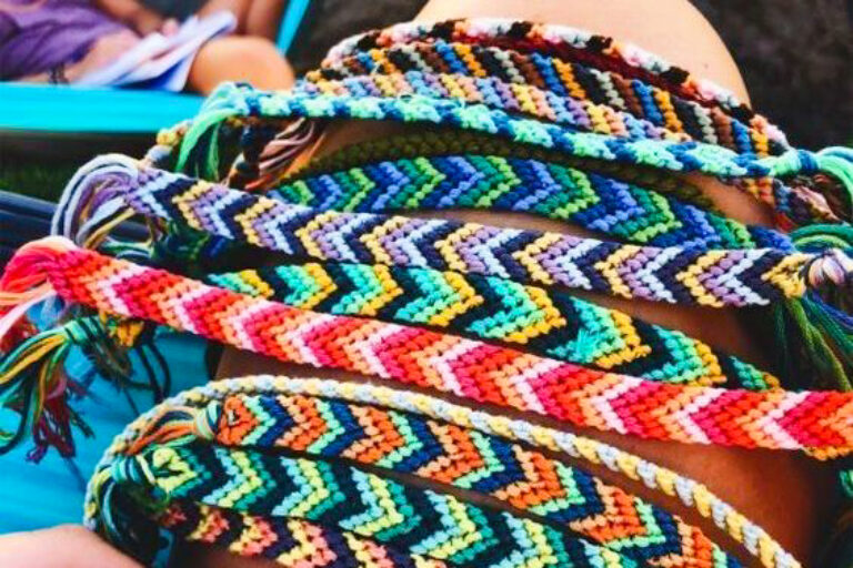 a bunch of friendship bracelets on someones arm.