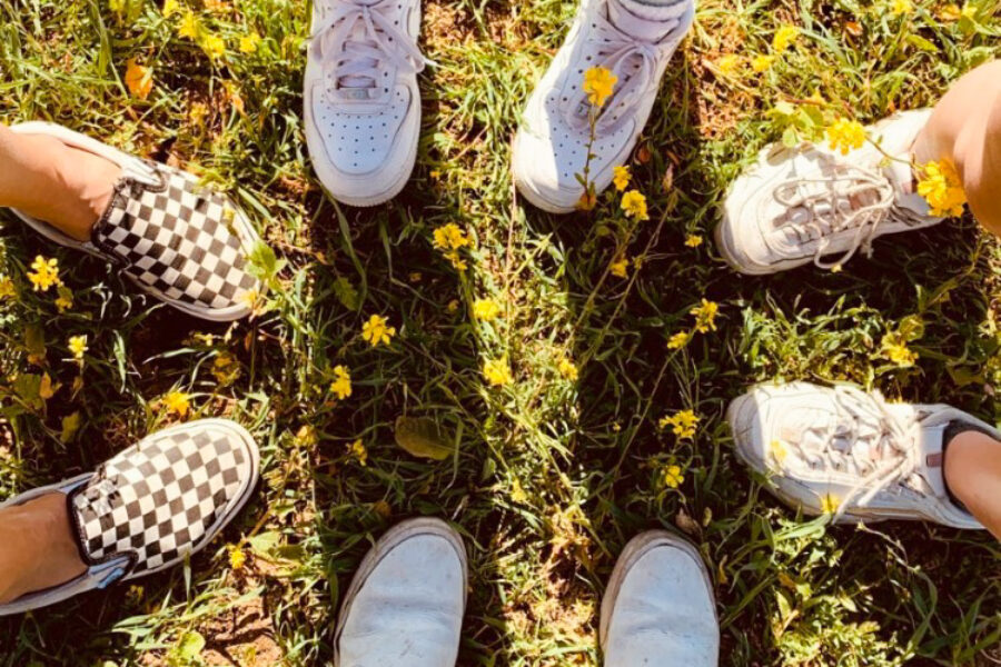 feet arranged in a circle on the grass.