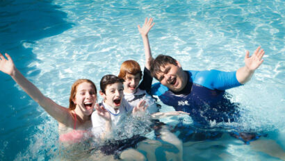 group of kids smiling in the water.