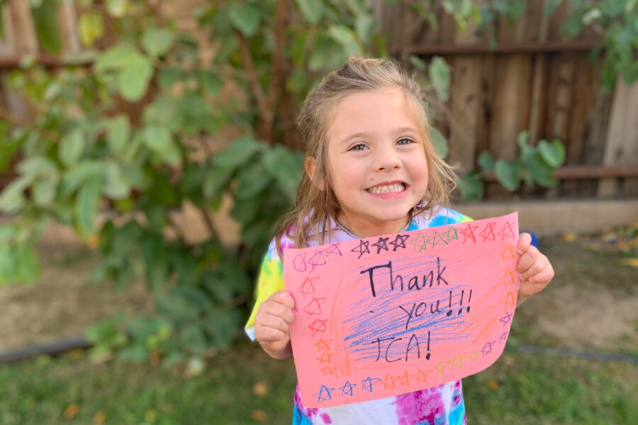 girl holding thank you sign.